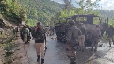 Armed security personnel walk at a site of an attack inspecting charred army vehicle after unidentified gunmen opened fire at an Indian army vehicle in the disputed Himalayan region of Kashmir on April 20, 2023 in this screengrab obtained from a video. (Reuters)