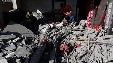 A man picks up a child at the site of an Israeli airstrike amid Israel-Gaza fighting in Deir al-Balah town in the central Gaza Strip, May 13, 2023. REUTERS/Ibraheem Abu Mustafa