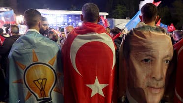 Supporters drapped in the flags of the AK Party, Turkish Flag and image of Turkish President Tayyip Erdogan stand outside the AK Party headquarters after polls closed in Turkey's presidental and parliamentary elections in Ankara, Turkey May 15, 2023. (AFP)