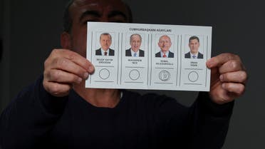 An election worker displays a stamped ballot after the polling station closed, during Turkish presidential and parliamentary elections, in Hatay, Turkey May 14, 2023. REUTERS/Emilie Madi