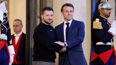 Ukraine's President Volodymyr Zelenskyy (L) is welcomed by France's President Emmanuel Macron (c) upon his arrival at the Elysee presidential palace in Paris on May 14, 2023. (AFP)