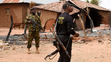 Security personnel stand guard in the Kukawa Village in the Kanam Local Government Area of the Plateau state on April 12, 2022 after resident’s houses were burnt down during an attack by bandits. (AFP)