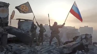 Wagner mercenary group fighters wave flags of Russia and Wagner group on top of a building in an unidentified location, in the course of the Russia-Ukraine conflict, in this still image obtained from a video released on May 20, 2023, along with a statement by Russian mercenary chief Yevgeny Prigozhin about taking full control of the Ukrainian city of Bakhmut. Press service of Concord/Handout via REUTERS ATTENTION EDITORS - THIS IMAGE WAS PROVIDED BY A THIRD PARTY. NO RESALES. NO ARCHIVES. MANDATORY CREDIT. TPX IMAGES OF THE DAY