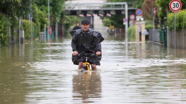 A man rides on a bicycle through floodwaters after heavy rains hit Italy's Emilia Romagna region, in Lugo, Italy, May 19, 2023. REUTERS/Claudia Greco TPX IMAGES OF THE DAY