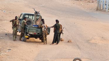 Soldiers of the Sudanese army stand near their vehicle on a road blocked with bricks in Khartoum on May 20, 2023, as violence between two rival generals continues. (AFP)