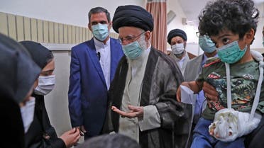 A handout picture provided by the office of Iran’s Supreme Leader Ali Khamenei on November 2, 2022 shows him greeting Artin Serayedaran, who lost his parents in a deadly attack on the Shah Cheragh mausoleum, in the capital Tehran. (AFP)