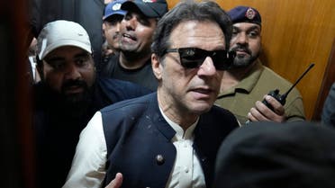 Former Pakistani Prime Minister Imran Khan, center, leaves court after an appearance in Lahore, Pakistan, Friday, May 19, 2023. Khan dialed down his campaign of defiance on Friday, saying he would allow a police search of his home over allegations that he was harboring suspects wanted in recent violence during anti-government protests by his supporters. (AP Photo/K.M. Chaudary)