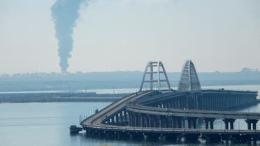 A view across the Kerch Strait shows smoke rising above a fuel depot near the Crimean bridge in the village of Volna in Russia's Krasnodar region as seen from a coastline in Crimea, May 3, 2023. (Reuters)