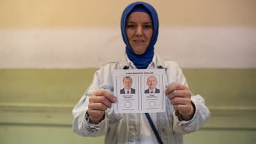 A woman holds ballot papers showing Turkish presidential candidates Recep Tayyip Erdogan (R) and Kemal Kilicdaroglu at a polling station during Turkey's presidental elections in Kocaeli on May 28, 2023. (Photo by Umit Turhan Coskun / AFP)