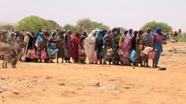 Halime Adam Moussa, a Sudanese refugee who is seeking refuge in Chad for a second time, stands in line with other people to receive her food portion from World Food Programme (WFP), near the border between Sudan and Chad in Koufroun, Chad, May 9, 2023. REUTERS/Zohra Bensemra