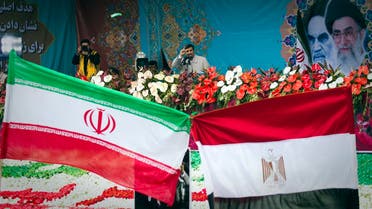 Protesters wave large Iranian (L) and Egyptian flags knotted together as Iranian President Mahmoud Ahmadinejad speaks on the 32nd anniversary of the Islamic Revolution in Tehran’s Azadi (Freedom) Square February 11, 2011. (Reuters)