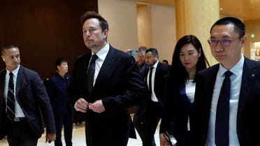 Tesla Chief Executive Officer Elon Musk walks next to Tesla's Senior Vice President Tom Zhu and Vice President Grace Tao as he leaves a hotel in Beijing, China May 31, 2023.  (Reuters)