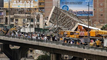 Police and civil defence gather as a collapsed billboard is removed from the October 6 overpass bridge in the Ghamra neighbourhood in central Cairo on June 1, 2023 during a sandstorm. (AFP)