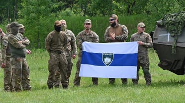 A deputy commander for the Freedom of Russia Legion, who gave his call sign as Caesar (3rd R), stands with fellow fighters during a presentation for the media in northern Ukraine, not far from the Russian border, on May 24, 2023. (AFP)