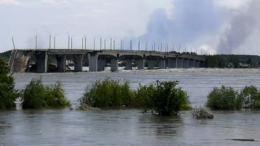 TOPSHOT - This general view shows a partially flooded area near The Antonovskiy Bridge (REAR) on the outskirts of Kherson, on June 6, 2023, following damage sustained at Kakhovka hydroelectric dam. A Russian-held dam in southern Ukraine was damaged on June 6, with Kyiv and Moscow accusing each other of blowing it up while locals were forced to flee rising waters. The dam was partially destroyed by multiple strikes, Moscow-installed authorities claimed just as expectations were rising over the start of Ukraine's long-awaited offensive. (Photo by Oleg TUCHYNSKY / AFP)