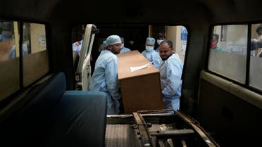 Healthcare workers carry the body of a person who died in Friday's train accident in Balasore, into an ambulance at the All India Institute of Medical Sciences hospital in Bhubaneswar in the eastern state of Orissa, India, Monday, June 5, 2023. (AP)