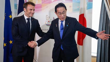 Japan’s Prime Minister Fumio Kishida (R) shakes hands with France’s President Emmanuel Macron before their meeting during the G7 Leaders’ Summit in Hiroshima on May 19, 2023. (AFP)