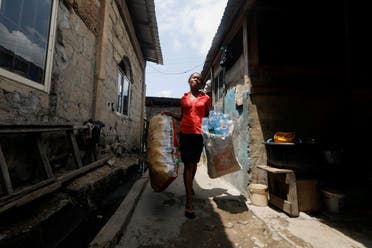 Elizabeth Samuel, 37, a parent of a student of My Dream Stead, a low-cost school that accepts recyclable wastes as payment, carries sacks of plastic waste for submission in Ajegunle, Lagos, Nigeria May 19, 2023. (REUTERS)