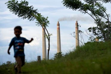 A young boy plays on a hill called 'Teletubbies Hill', a locally popular tourist attraction, as the chimneys of Suralaya coal power plant loom in the background, in Cilegon, Indonesia, Jan. 8, 2023. A report released Wednesday, June 7, 2023, by the International Energy Agency says that demand for energy is growing, yet emissions are not growing as fast. (File photo: AP)