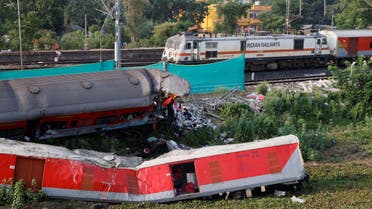 A train moves past damaged coaches, after the tracks were restored, at the site of a train collision following the accident in Balasore district in the eastern state of Odisha, India, June 5, 2023. (Reuters)