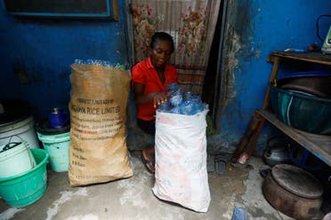 Elizabeth Samuel, 37, a parent of a student of My Dream Stead, a low-cost school that accepts recyclable waste as payment, arranges used plastic bottles into a sack in her home in Ajegunle, Lagos, Nigeria May 19, 2023. (REUTERS)