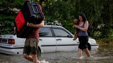 Local residents carry their personal belongings on a flooded street, after the Nova Kakhovka dam was breached, amid Russia’s attack on Ukraine, in Kherson, Ukraine, on June 6, 2023. (Reuters)