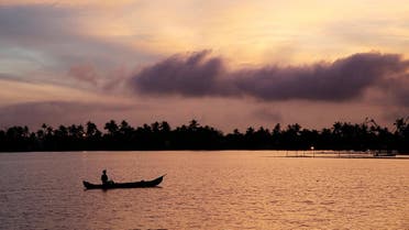 A man rows his boat in the tributary waters of Vembanad Lake against the backdrop of pre-monsoon clouds on the outskirts of Kochi, India, on June 7, 2019. (Reuters)