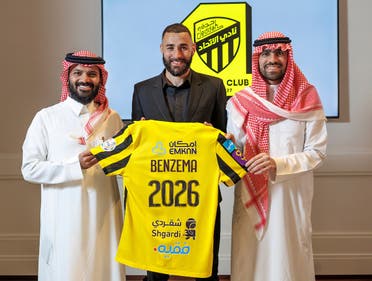In this handout picture release by the Saudi Pro League on June 6, 2023, French football player Karim Benzema holds the jersey of Saudi Arabia’s Al Ittihad club as he poses for a picture flanked by Al Ittihad members, in Madrid. (AFP)