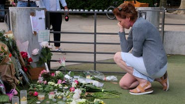 A woman pays respect in front of messages and floral tributes at the children's playground the day after several children and adults were injured in a knife attack at the Le Paquier park near the lake in Annecy, in the French Alps, France, June 9, 2023. (Reuters)
