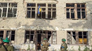 Ukrainian soldiers stand in front of a building with a Ukrainian flag on it, during an operation that claims to liberate the first village amid a counter-offensive, in a location given as Blahodatne, Donetsk Region, Ukraine, in this screengrab taken from a handout video released on June 11, 2023. 68th Separate Hunting Brigade 'Oleksy Dovbusha'/Handout via REUTERS THIS IMAGE HAS BEEN SUPPLIED BY A THIRD PARTY. NO RESALES. NO ARCHIVES. MANDATORY CREDIT. REUTERS WAS NOT ABLE TO INDEPENDENTLY VERIFY THE LOCATION OF THE VIDEO AND THE DATE IT WAS FILMED.