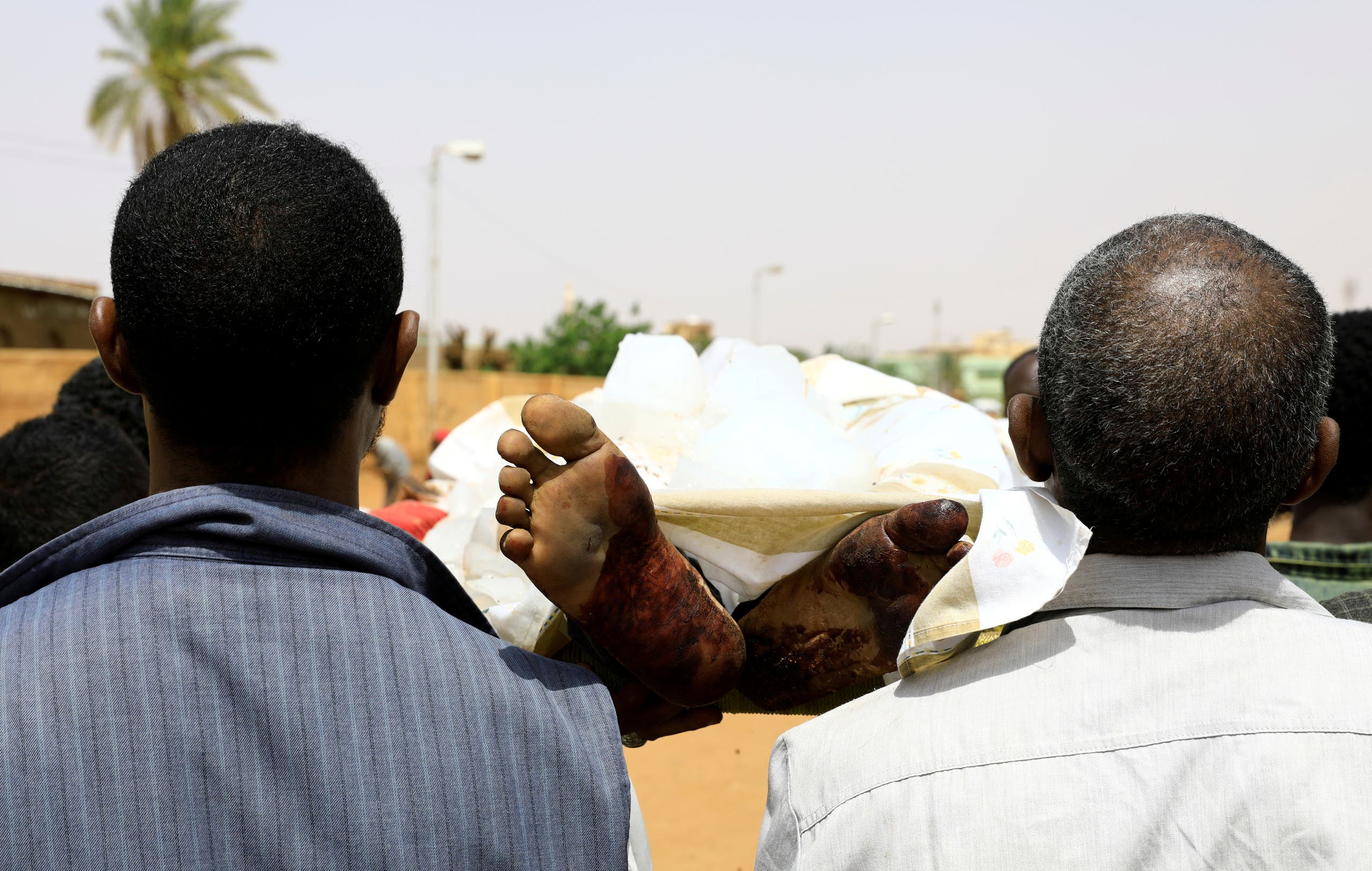 سودانيون ينقلون إحدى الجثث في الخرطوم - أرشيفية من رويترز