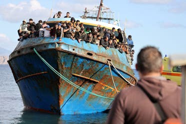 مهاجرون يقفون على متن قارب صيد في  بعد عملية إنقاذ قبالة جزيرة باليونان- أرشيفية من رويترز
