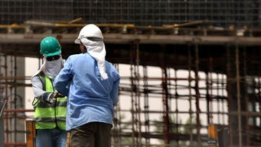 Asian workers cover their heads with white scarves to protect themselves from the strong sun as they work at a construction site in the Saudi capital Riyadh on June 7, 2011. (File photo: AFP)