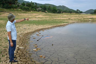 A local resident gesturing as he stands on cracked soil on an island formed inside Thac Ba hydropower lake in Yen Bai province, June 13, 2023. (AFP)