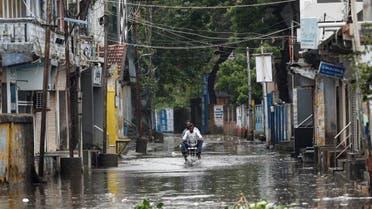 A man rides a motorcycle through a waterlogged street in Mandvi before the arrival of cyclone Biparjoy in the western state of Gujarat, India, June 15, 2023. REUTERS
