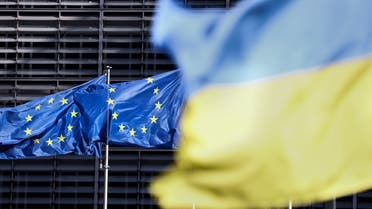 A picture taken on May 16, 2022 shows flags of the European Union and Ukraine outside the European Council headquarters in Brussels. (AFP)