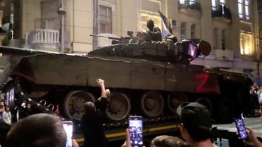مواطنون روس يلتقطون صورا للمعدات والآليات العسكرية أثناء مغادرة قوات فاغنر لمدينة روستوف 