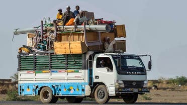 People ride with furniture and other items atop a truck moving along a road from Khartoum to Wad Madani at the locality of Kamlin, about 80 kilometres southeast of Khartoum, on June 22, 2023. (AFP)