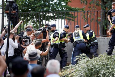 Police officers intervene after people’s reaction as demonstrators burn the Quran (not pictured) outside Stockholm’s central mosque in Stockholm, Sweden, on June 28, 2023. (Reuters)