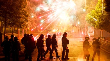 French police stand in position as fireworks go off during clashes with youth, after the death of Nahel, a 17-year-old teenager killed by a French police officer during a traffic stop, in Nanterre, Paris suburb, France, June 30, 2023. (Reuters)