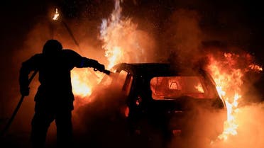 A French firefighter works to extinguish a burning car during the fifth day of protests following the death of Nahel, a 17-year-old teenager killed by a French police officer in Nanterre during a traffic stop, in Tourcoing, France, on July 2, 2023. (Reuters)