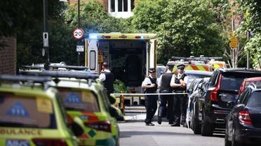 Police officers stand guard next to an ambulance behind a cordon following a car collision at the private Study Prep girls' school in Wimbledon, southwest London, on July 6, 2023. (AFP)