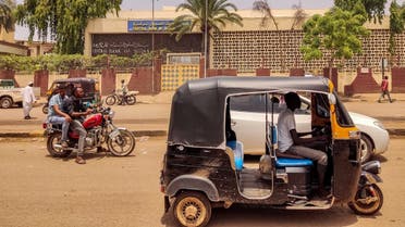 A tuk-tuk (motorised rickshaw) and a motorcycle move along a road past a branch of the Central Bank of Sudan in the country's eastern city of Gedaref on July 9, 2023. (AFP)