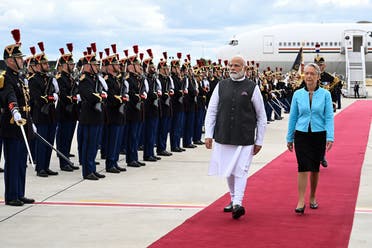 India’s Prime Minister Narendra Modi (2R) and France’s Prime Minister Elisabeth Borne (R) walk past French Republican Guards at the Orly airport in Orly, Paris’ suburb, on July 13, 2023. (AFP)