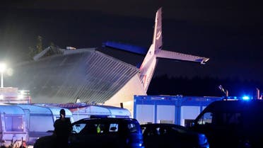 The tail of a Cessna 208 plane sticks out of a hangar after it crashed there in bad weather killing several people and injuring others, at a sky-diving centre in Chrcynno, central Poland, on Monday, July 17, 2023. (AP)