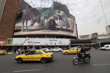 Iranians drive at Vali-Asr Square in the capital Tehran near a billboard marking the beginning of Islam’s Muharram month on July 31 2022. (AFP)