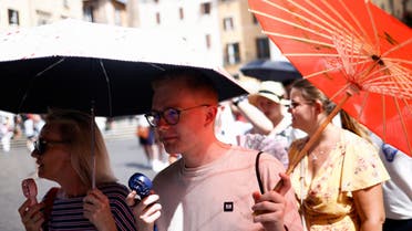 Bradley Davies and Paula Davies from Britain use fans to cool off, and umbrellas to shelter from the sun, as they queue to enter the Pantheon, during a heatwave across Italy, as temperatures are expected to cool off in the Italian capital, in Rome, Italy July 19, 2023. (Reuters)
