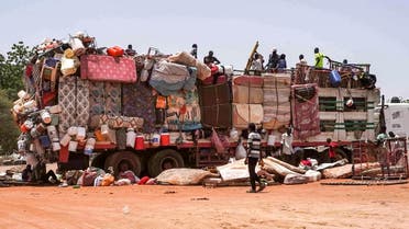 People sit atop a truck carrying mattresses, plastic chairs, and other pieces of furniture parked along the road connecting Sudan's capital to the city of Wad Madani in al-Jazirah state, in Hasahisa on July 18, 2023. (AFP)