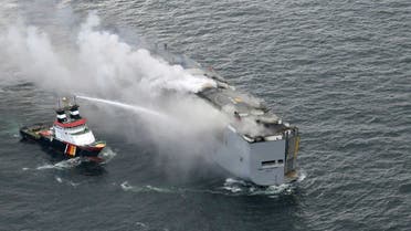A boat hoses the smoke from a fire which broke out on a freight ship in the North Sea, about 27 kilometers (17 miles) north of the Dutch island of Ameland, Wednesday, July 26, 2023. (AP)