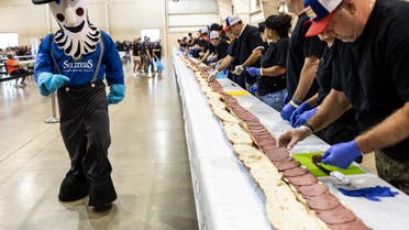 Volunteers assemble a 150-foot-long (45.7-meters-long) bologna sandwich at the Lebanon Area Fair on Tuesday, July 25, 2023 in Lebanon, Pa. Every footlong “bite” was sponsored at $100 per foot. The money was donated to Lebanon County Christian Ministries and their efforts to help people dealing with food insecurity in the Lebanon Valley. (Sean Simmers/The Patriot-News via AP)